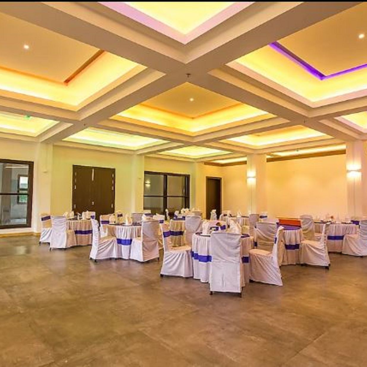 A wide view of chairs and tables in a closed hall with windows | Meeting Halls in Sanderling