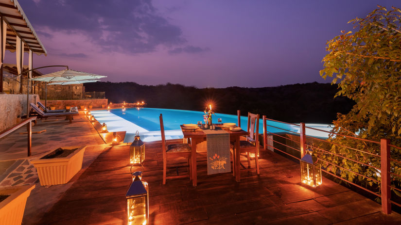 A view of the swimming pool with a table for two set up next to it - Chunda Shikar Oudi, Udaipur