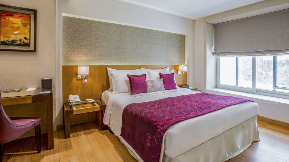 room with king size bed and wooden flooring at hotel bawa continental