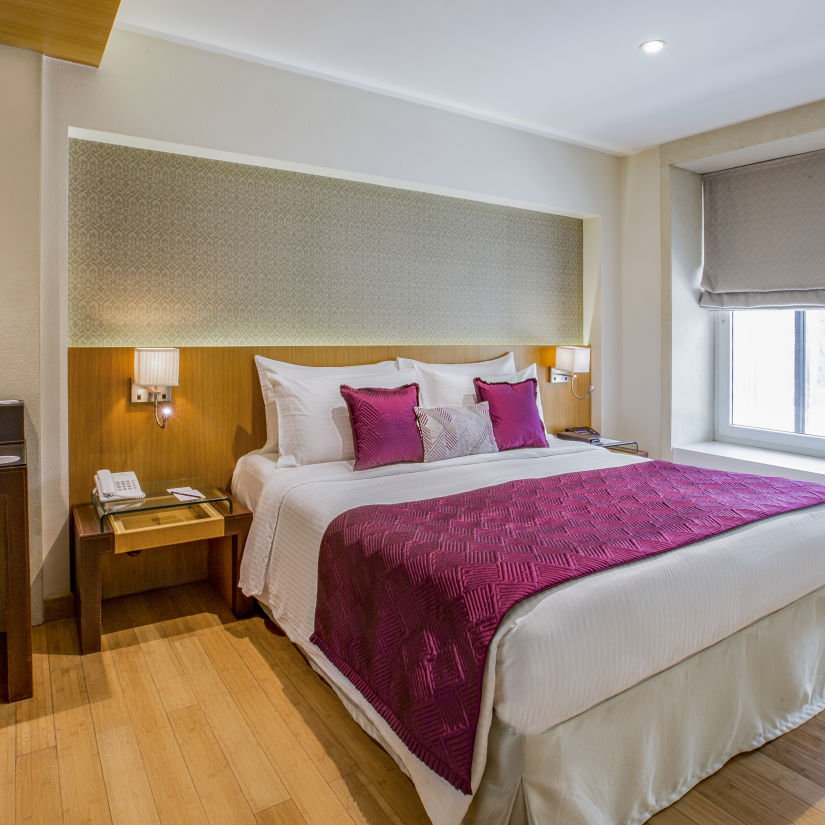 room with king size bed and wooden flooring at hotel bawa continental