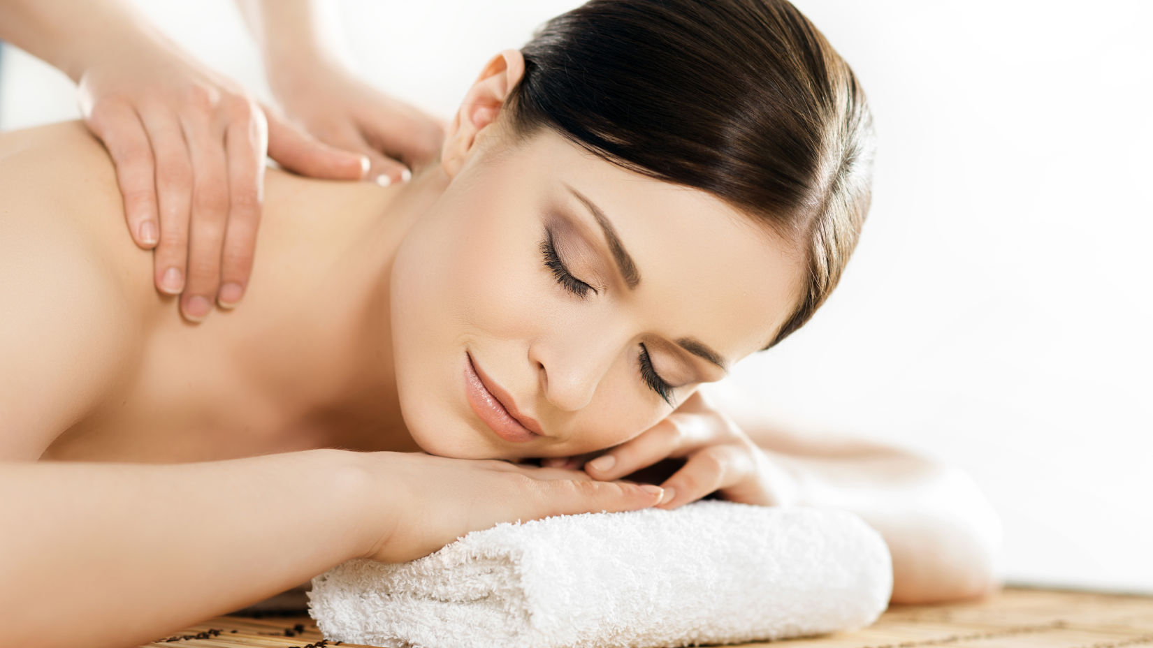 A woman resting her head on a towel and getting a massage 