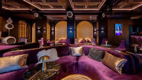 a large connected sofa with purple covers and a table in the middle - The Claridges, New Delhi