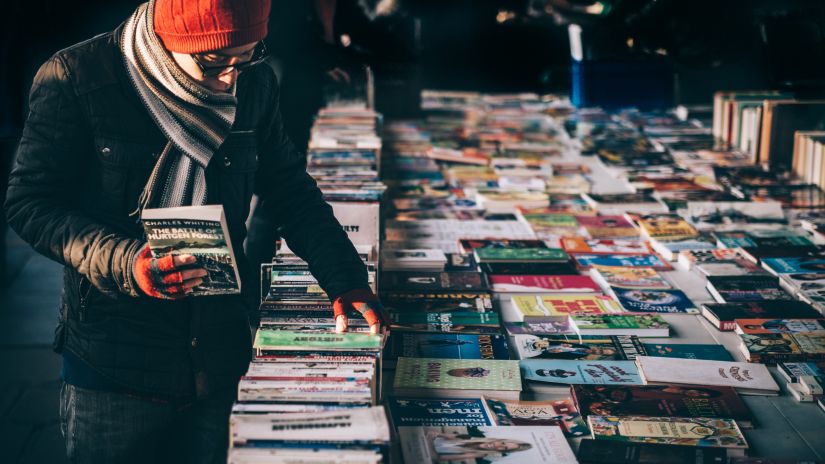 a person going through books at a shop