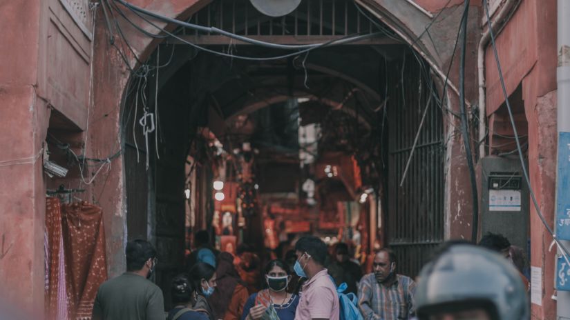 a lane filled with people going from under a fort 