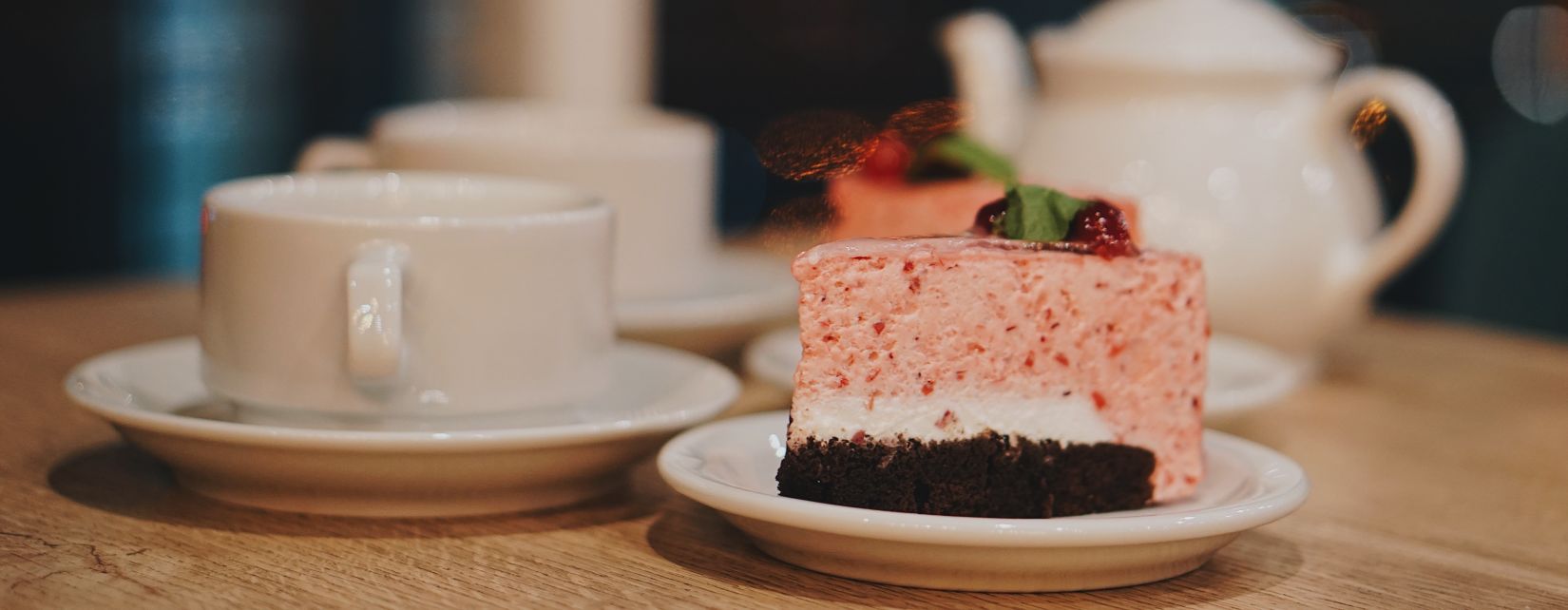 Delecious cake kept on table with tea kettle