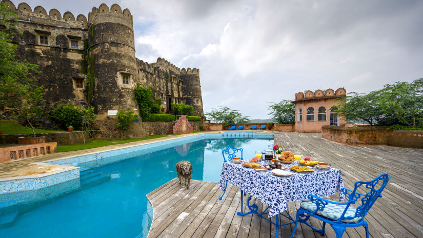 Hill Fort Kesroli 14th Century Alwar - image of a table and chair facing the property's swimming pool