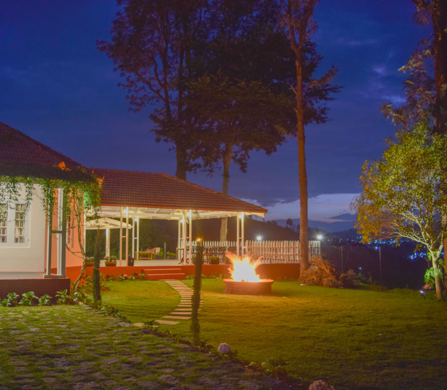 alt-text A cottage rests on a lawn late in the evening - Ibex Stays & Trails, Coonoor (Leewood)