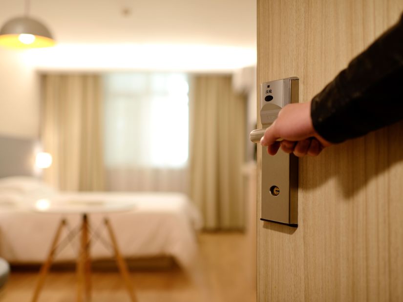 a man opening the door to his hotel room