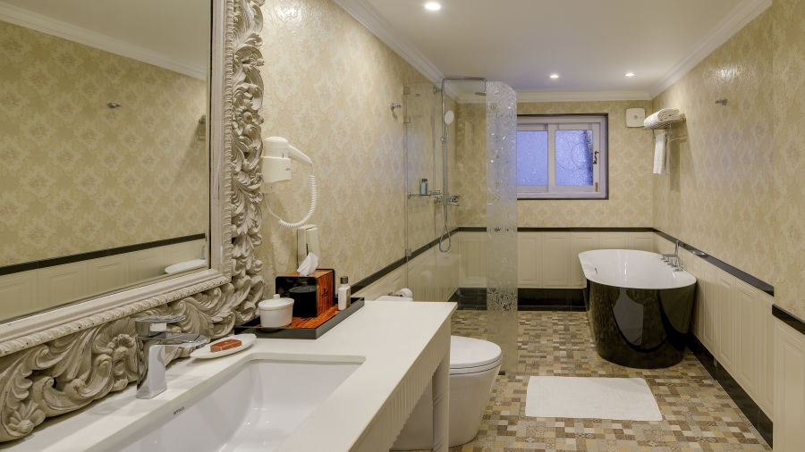 a bathroom with the washbasin placed on the left side and a mini bathtub on the right side - Mayfair Himalayan Spa Resort Kalimpong