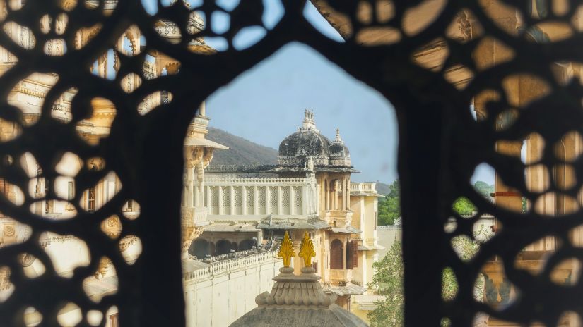 A view via a well carved lattice window of an elaborate edifice