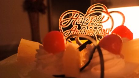 a cake with cherries on top and a happy anniversary card