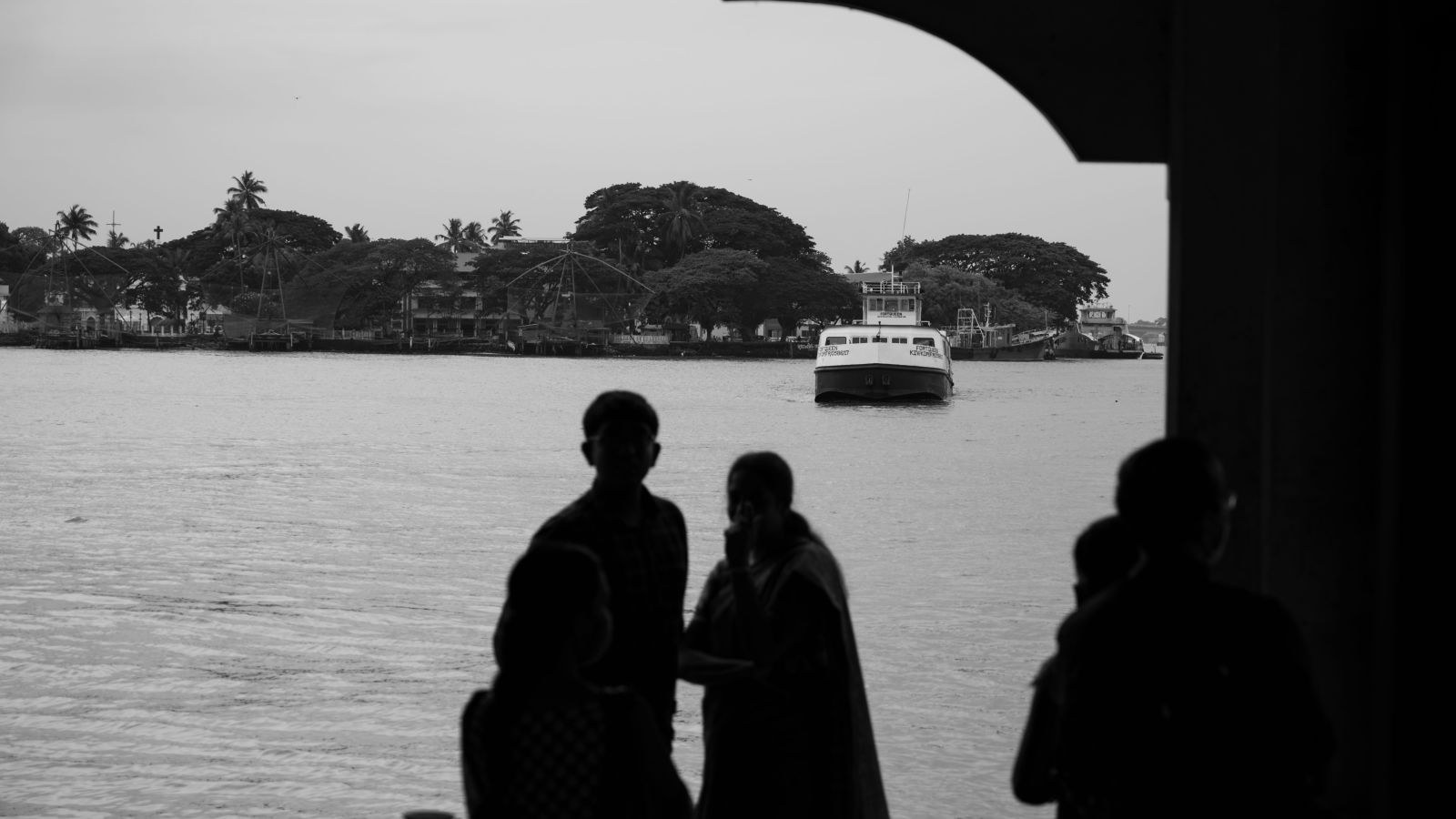 silhouettes of a people standing near fort kochi during the day