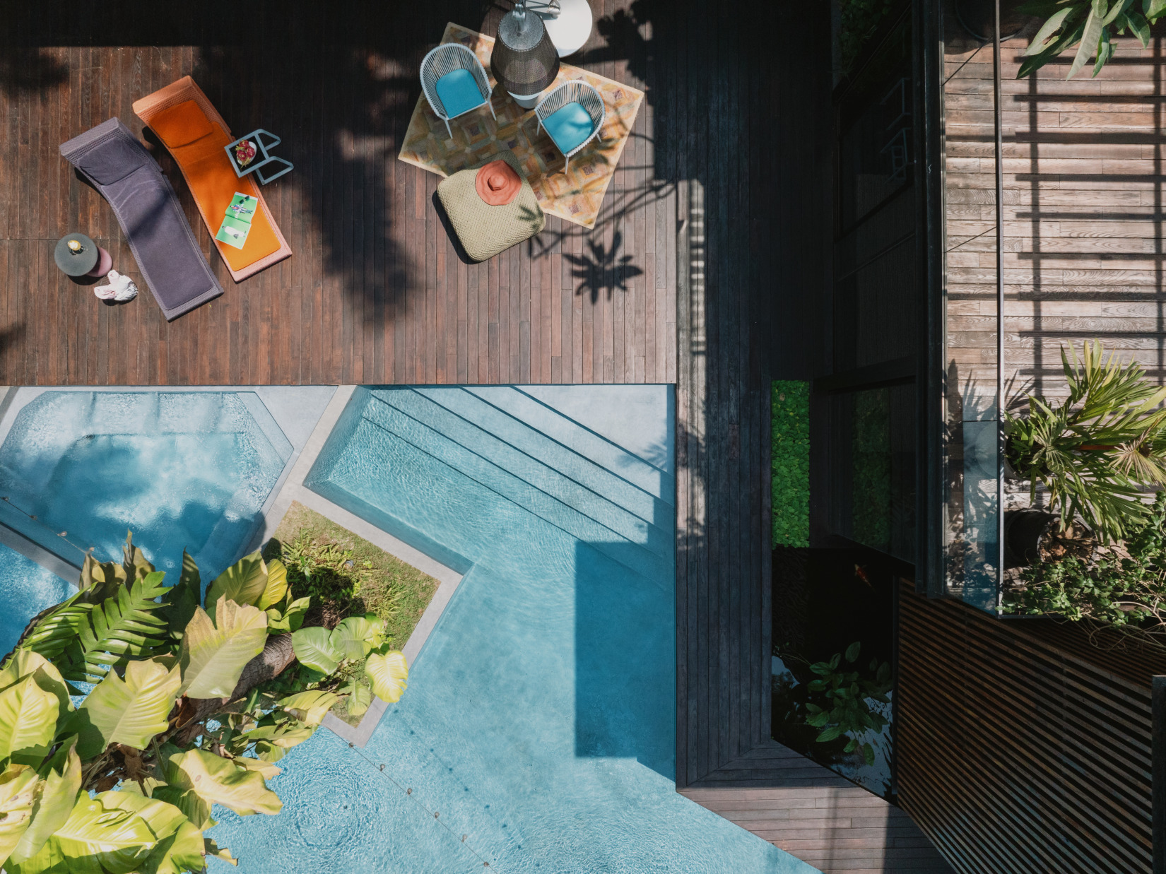 An aerial view of the resort beside the swimming pool, featuring two relaxing chairs.