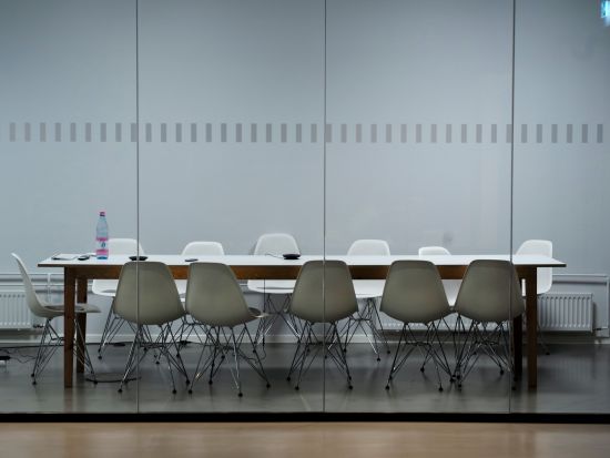 A meeting room with a rectangular table and grey seats