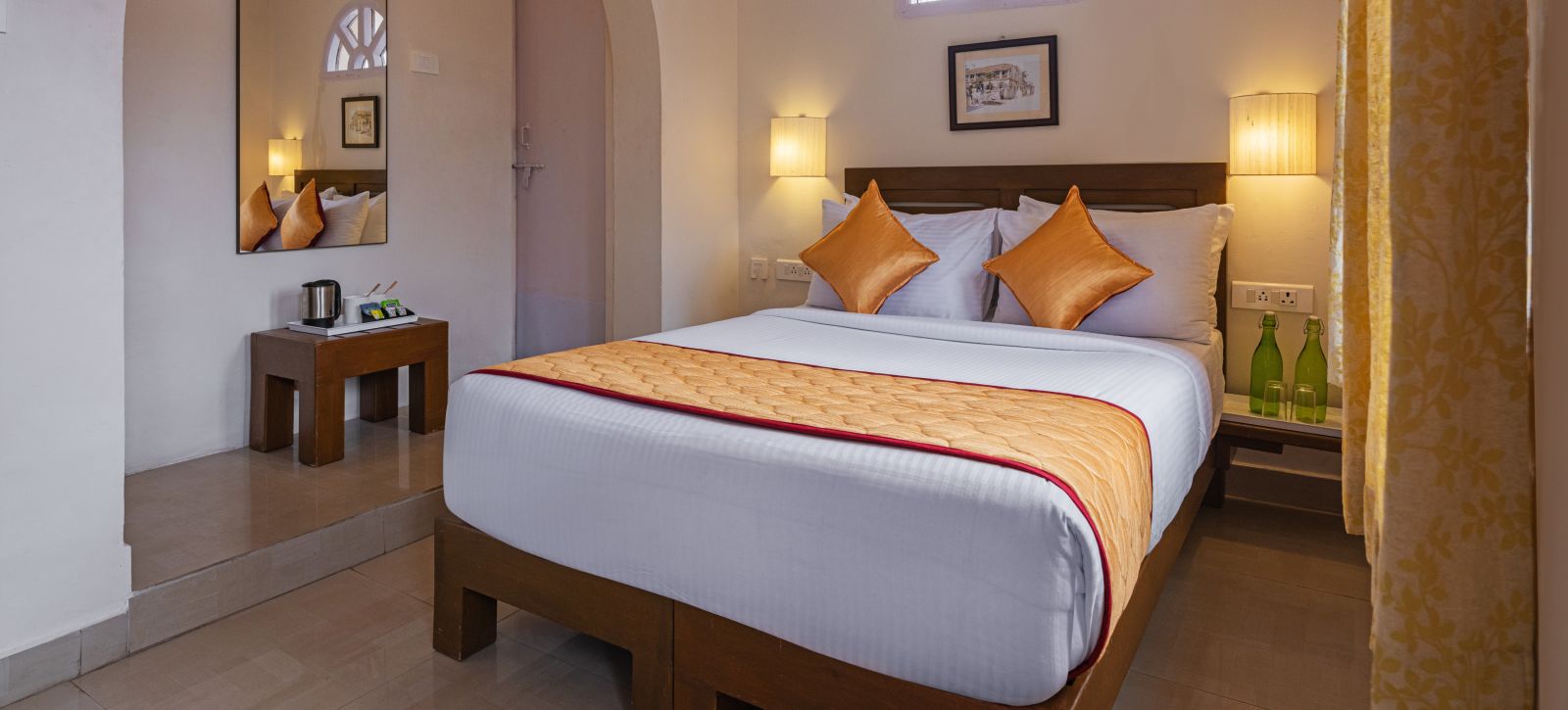 A bedroom with double-sized bed, lamps on each side ansd other amenities included | Mango Hill, Kodaikanal