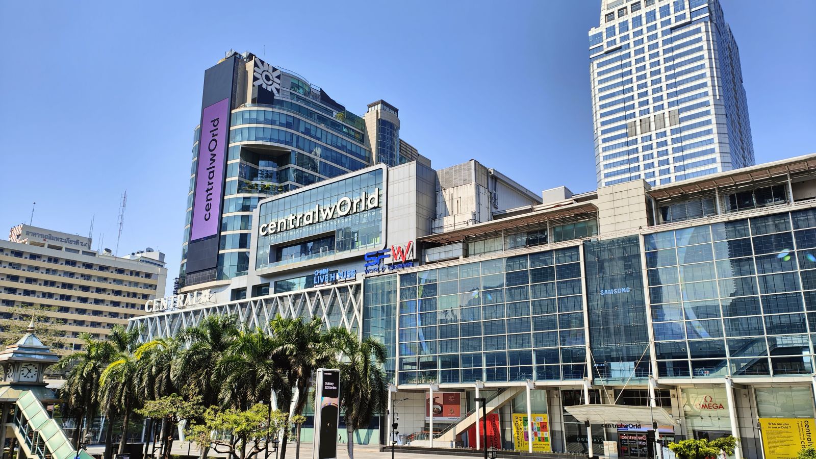 facade view of Central World building with trees and a sky walk in front of it