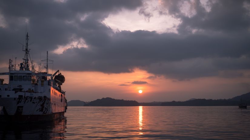 Sunset in the background with a ship in the ocean