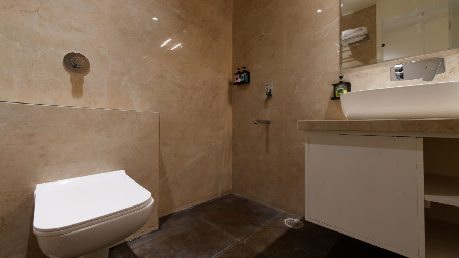 Washroom with modern amenities and mirror above the sink at Ankit Hotel, Jabalpur