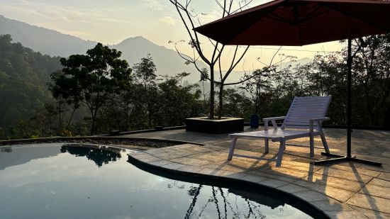 alt-text the swimming pool at Holistic Stay Eco Resort, Kannur featuring a sitout area overseeing the Brahmanagiri Mountains