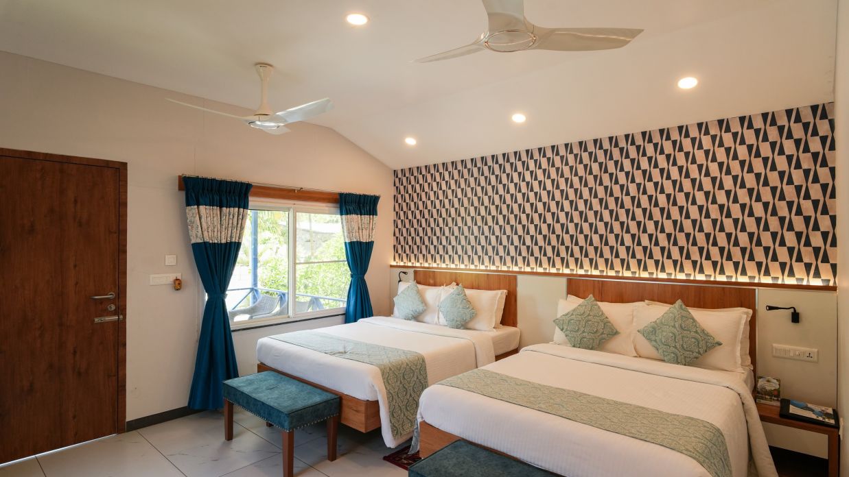 a bedroom with two double beds and a large window on the side - MGM Whispering Wind
