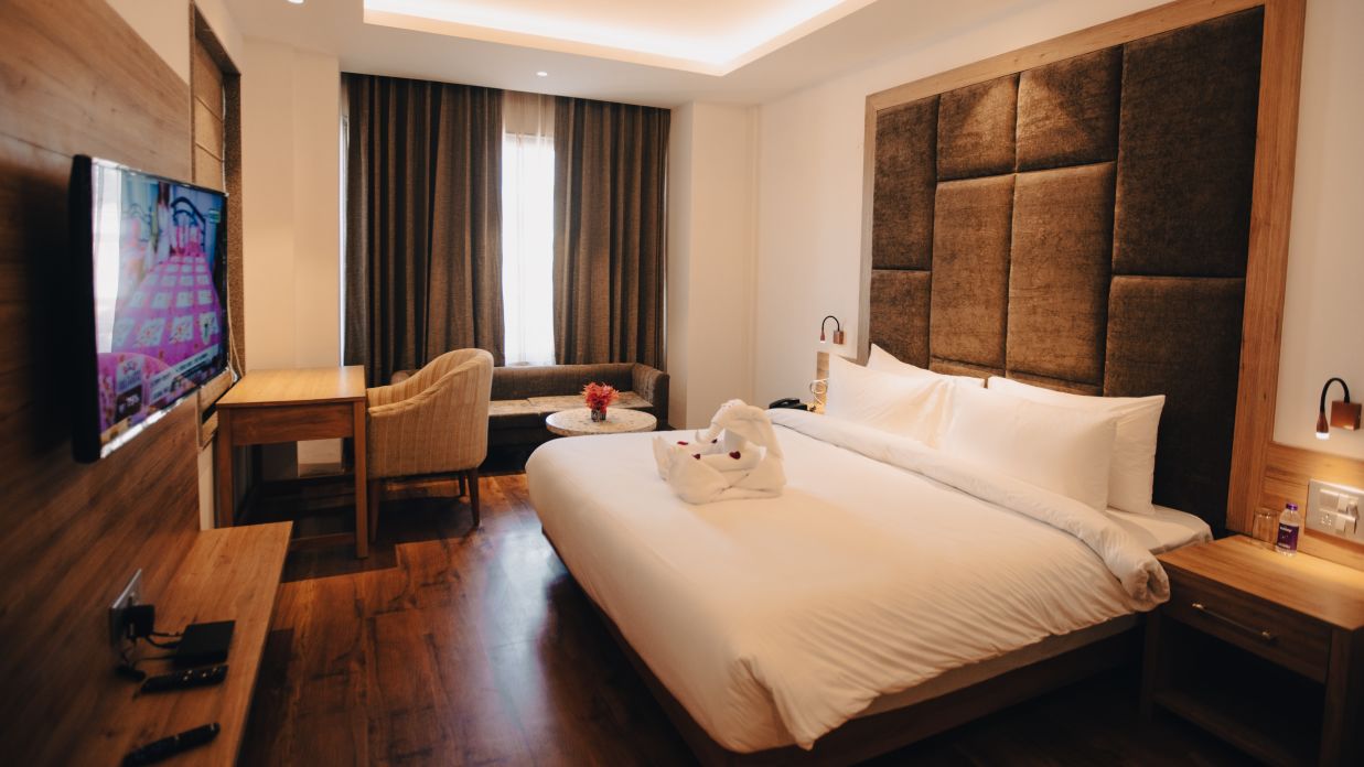 Clarks Inn Express Dehradun - interior view of the executive room featuring a king size bed wooden flooring and a television