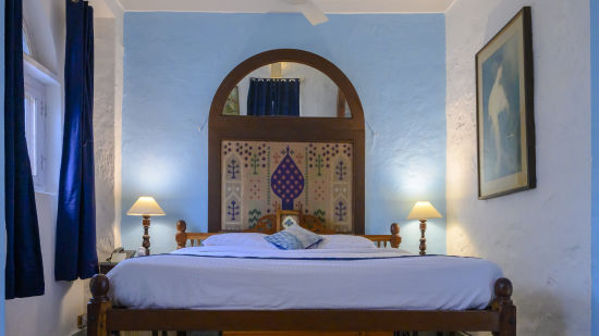 Hill Fort Kesroli 14th Century Alwar - interior view of the Sitara room with a king size bed and a painting on the wall