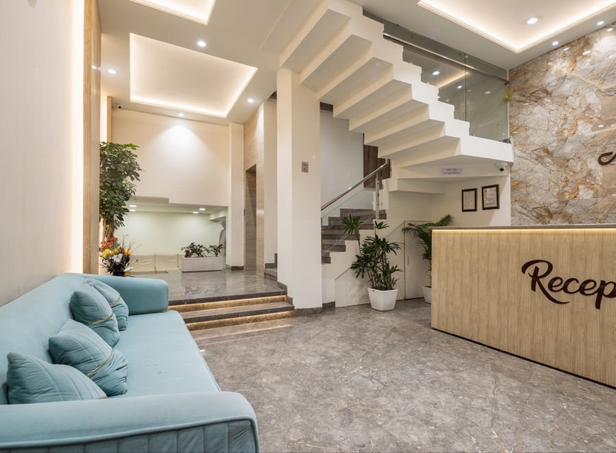 alt-text Reception area featuring a sofa and reception desk at Hotel Meghdoot, Bhopal