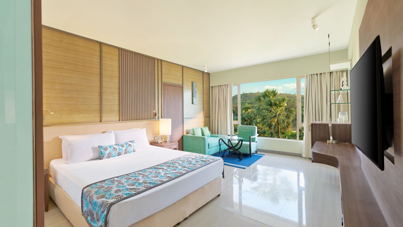 A view of the bedroom with a bed and glass window | The Resort