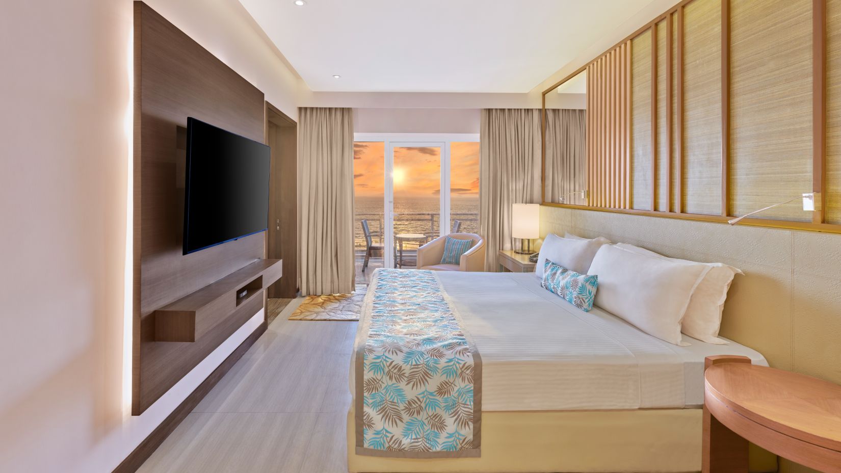 A side view of the room with with a bed and a TV on the wall | The Resort