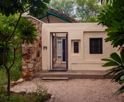 A front view of the cottage with greenery on either sides | Trees N Tigers