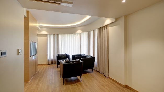 Well lit luxury room seating area with sofa seating and french windows at Hotel Mumbai House, Ghansoli