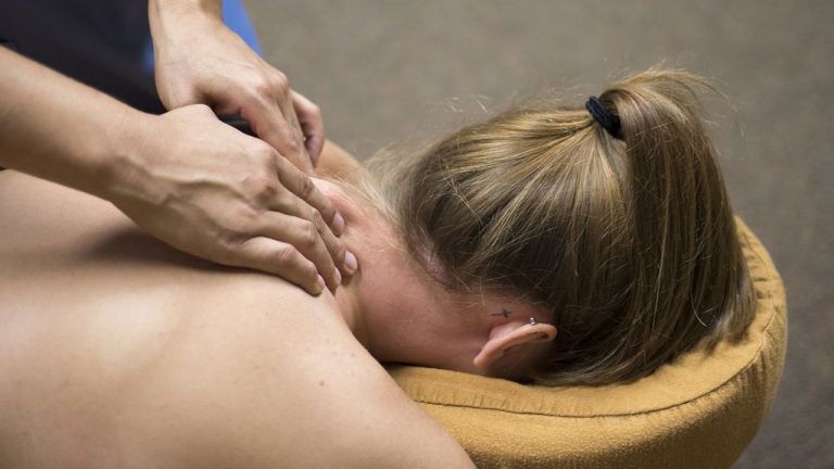 A person receiving a therapeutic shoulder massage.