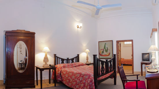 An overview of the Maharani Chakerian Wale room with a double, side tables, and a wardrobe bed in the background - The Baradari palace