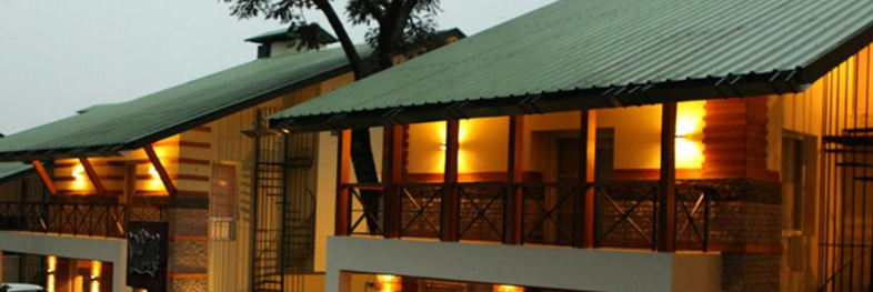 An enchanting exterior of our hotel decorated with aesthetic yellow lights and captured during sunset - Lamrin Norwood Green, Palampur