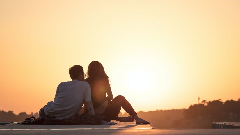 man and woman watching the sunset