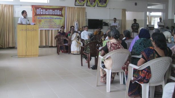 Man giving a speech as elderly woman listen