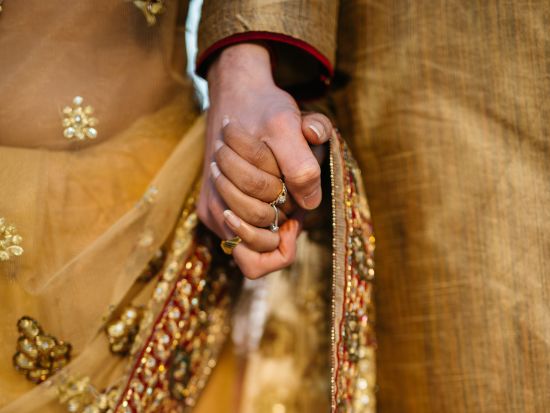 bride and groom holding hands in wedding attire