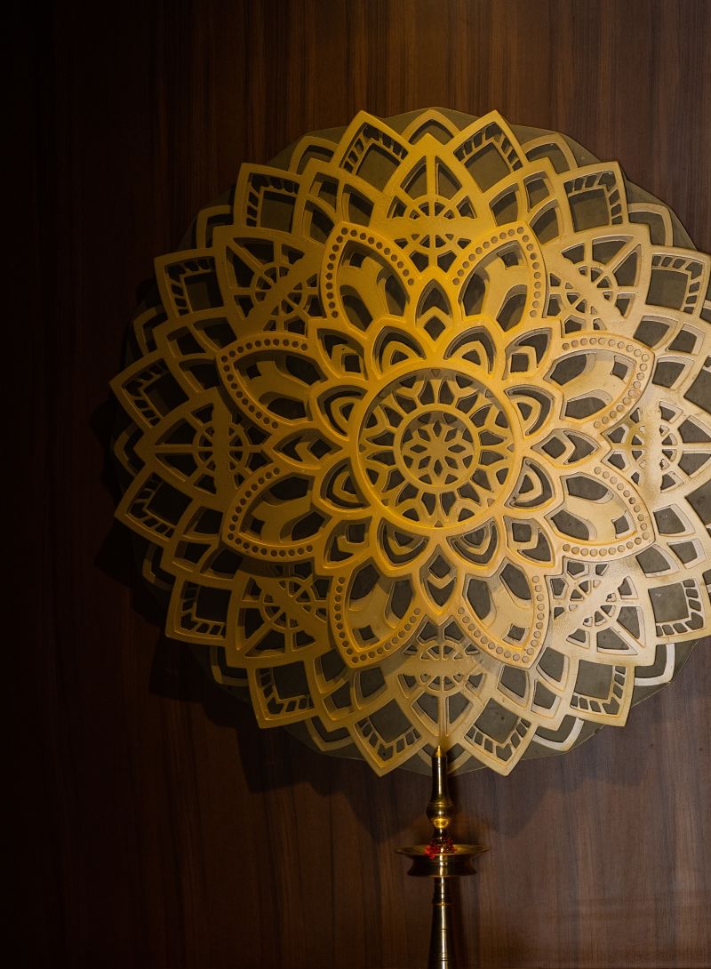 a lamp kept in froint of a mandala wall hanging