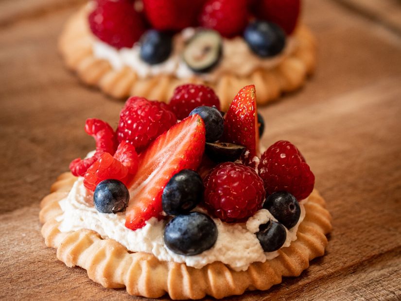 a tart with whipped cream and assorted berries on top