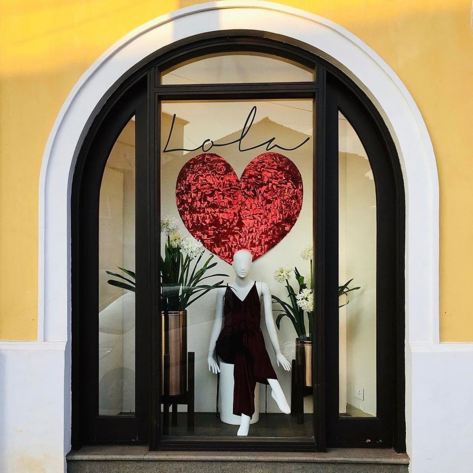 A mannequin with a dress on display outside a shop