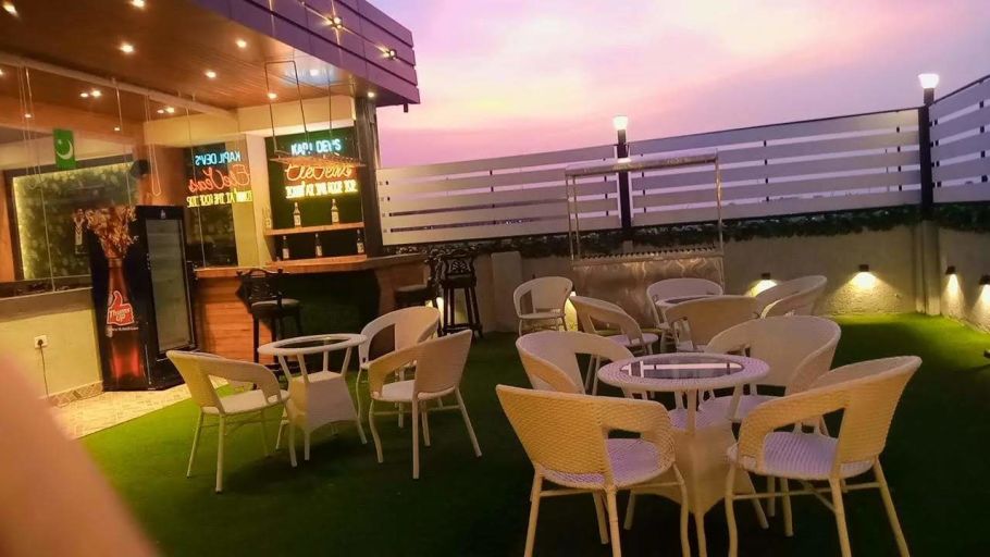an image of kapil dev eleven resto displaying a set of lounge chairs placed in open air - Click Hotel Capital House, Patna