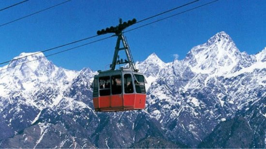 a cable car with snow-capped mountains in the backdrop