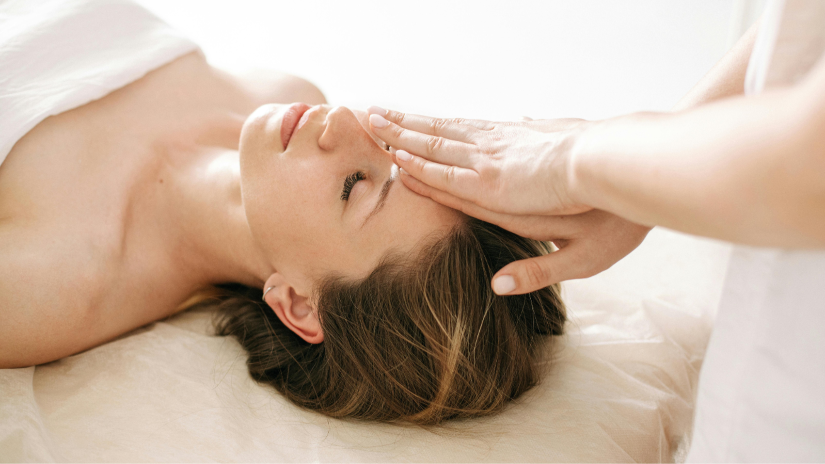 A woman receiving a relaxing facial treatment.