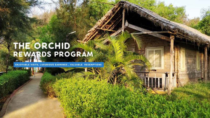 A picturesque wooden cabin surrounded by lush greenery, promoting  The Orchid Rewards Program, inviting guests to enjoy exclusive benefits and serene stays.