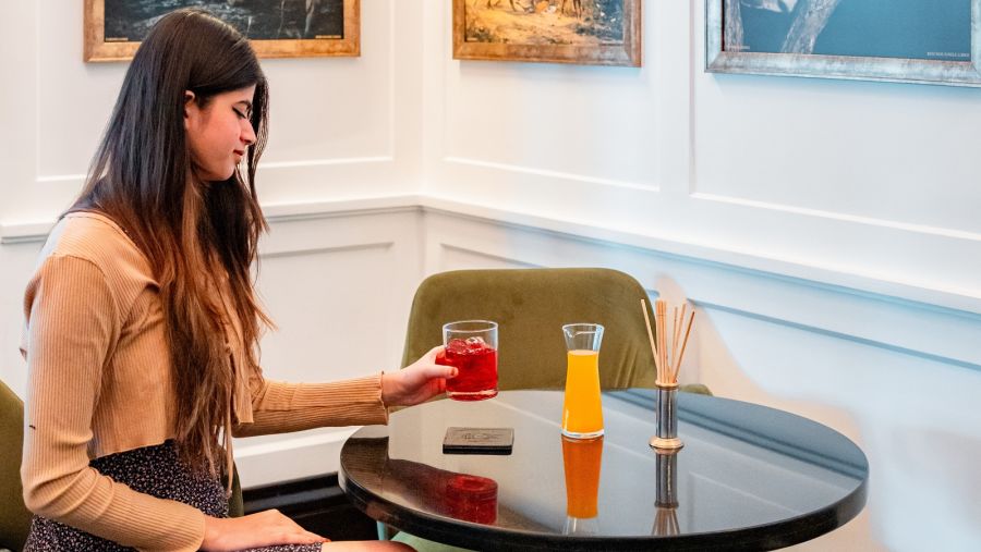 A girl enjoying her drink in the corner of the dining area at Jehan Numa Palace