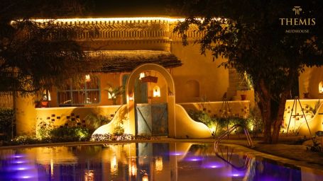 Night image of a building lined with lights at Themis Mudhouse- A Nature's Wellness Resort