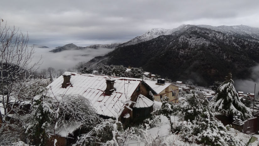 The Ramgarh Bungalows - bird eye view of snow covered bungalows enveloped by mountains