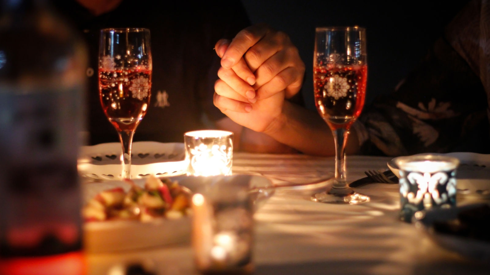 Hands held during romantic dinner