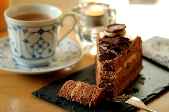 alt-text A cup of tea, and cake served in plate.