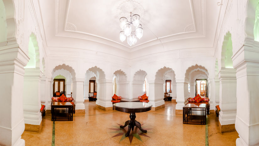 a centre table below a hanging chandelier at our restaurant - The Baradari Palace